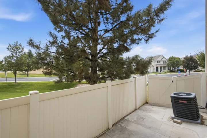 Paved patio area, privacy fencing, and mature trees