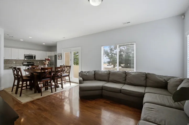 Hardwood-finish flooring, white cabinetry, integrated stainless steel appliances, and French doors