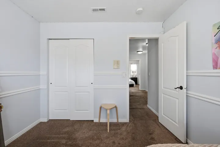 Wall molding accents, bi-fold closet doors, and carpet flooring