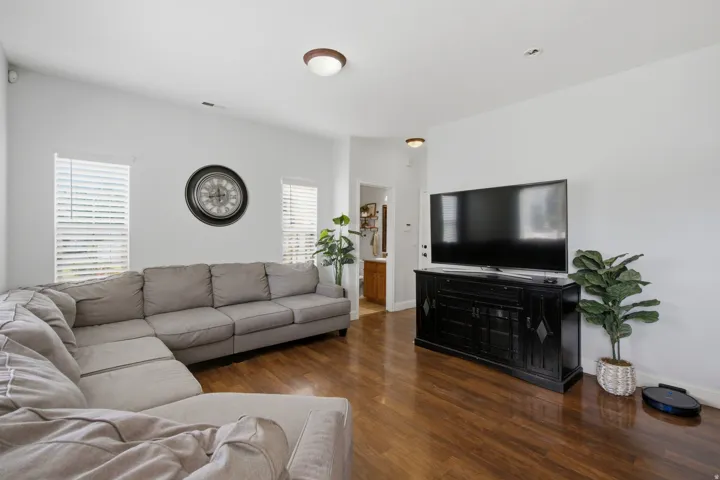 Wood-finish flooring throughout, white walls, and multiple windows with blinds