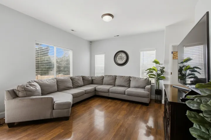 Wood-finish flooring, multiple windows with blinds, recessed lighting, and light-toned walls