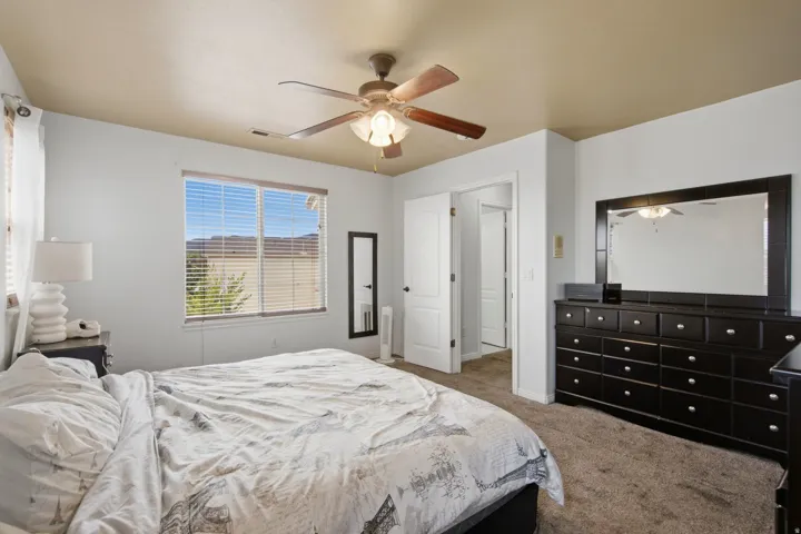 Room with light neutral wall paint, a ceiling fan, and carpet flooring