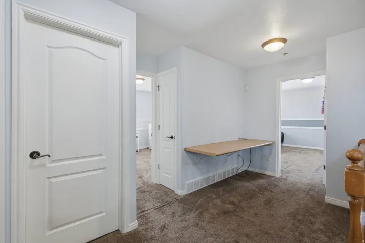 Hallway featuring carpet flooring and a built-in wall desk