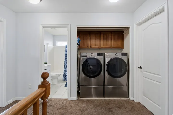 Dedicated laundry area with upper wood cabinetry