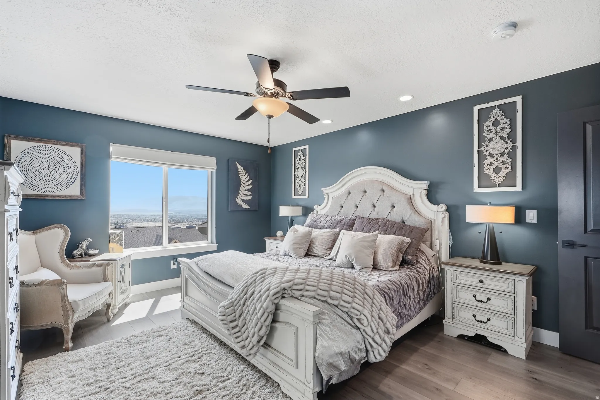 Wood-finish flooring, ceiling fan, expansive window, recessed lighting, and a solid core door