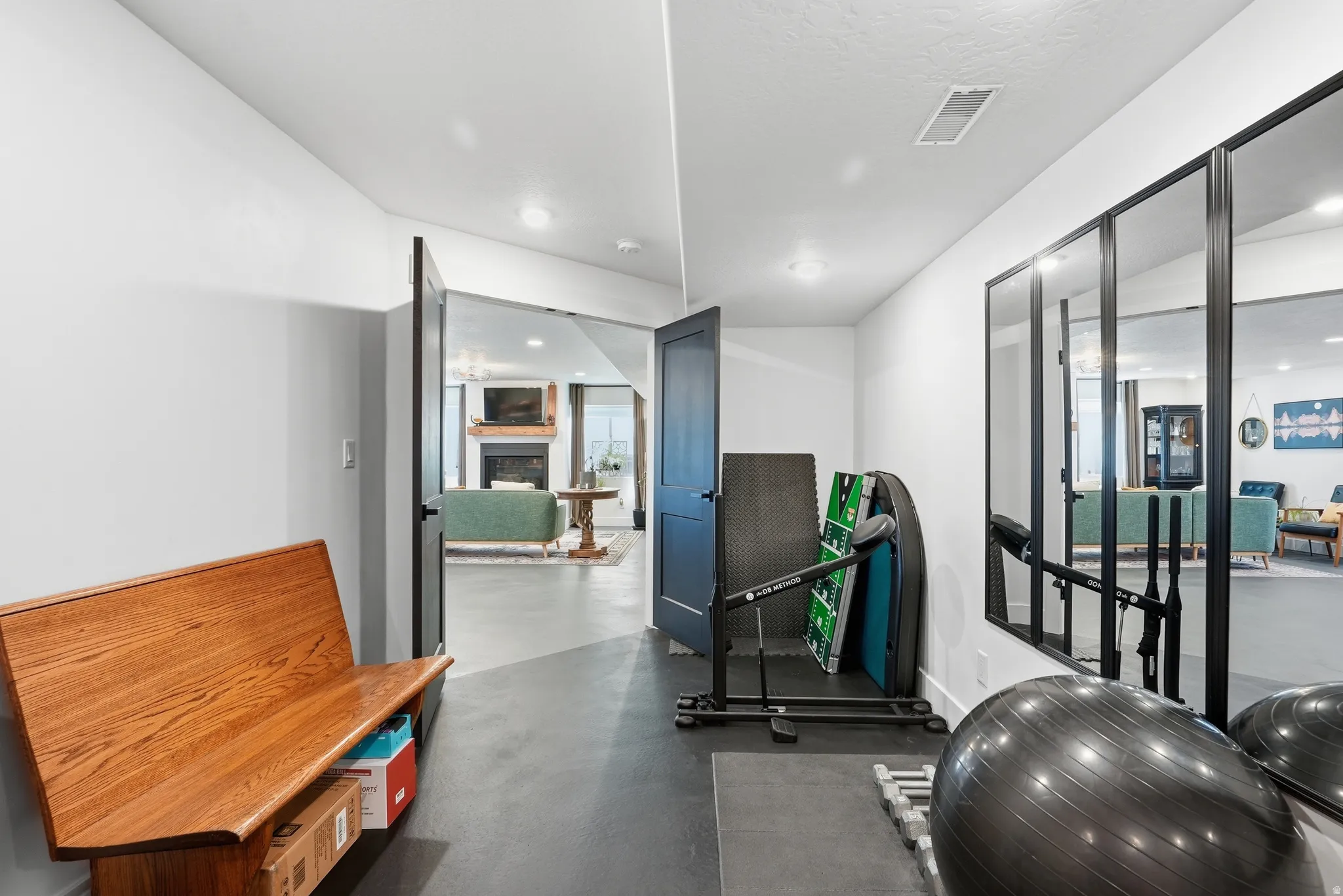 Recessed lighting illuminates the white walls and dark flooring