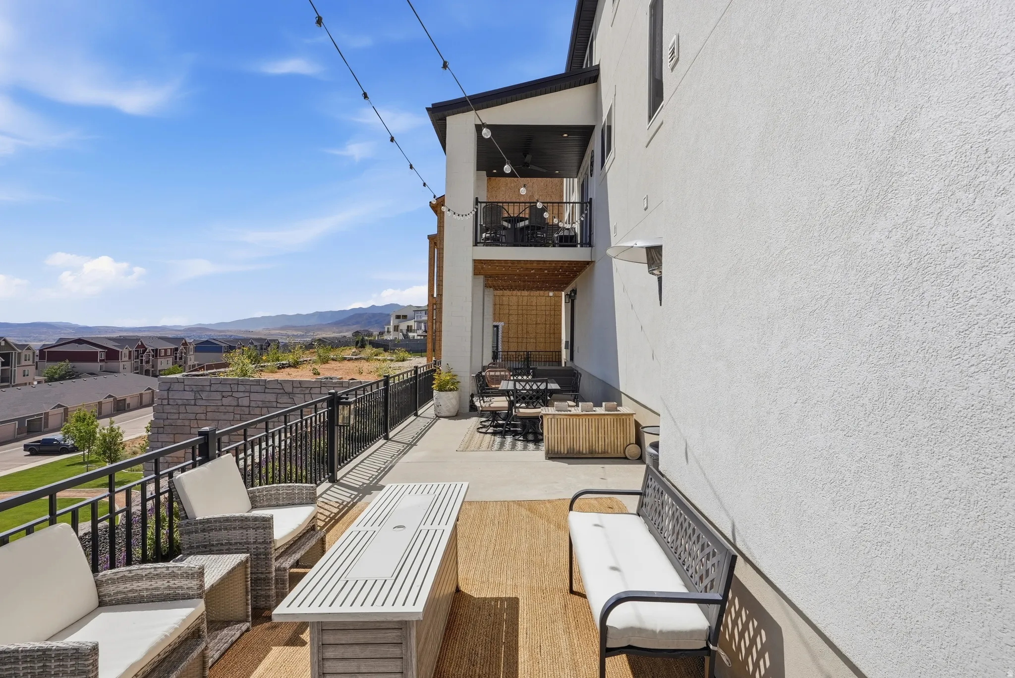 Multi-level outdoor deck with a metal railing and stucco exterior
