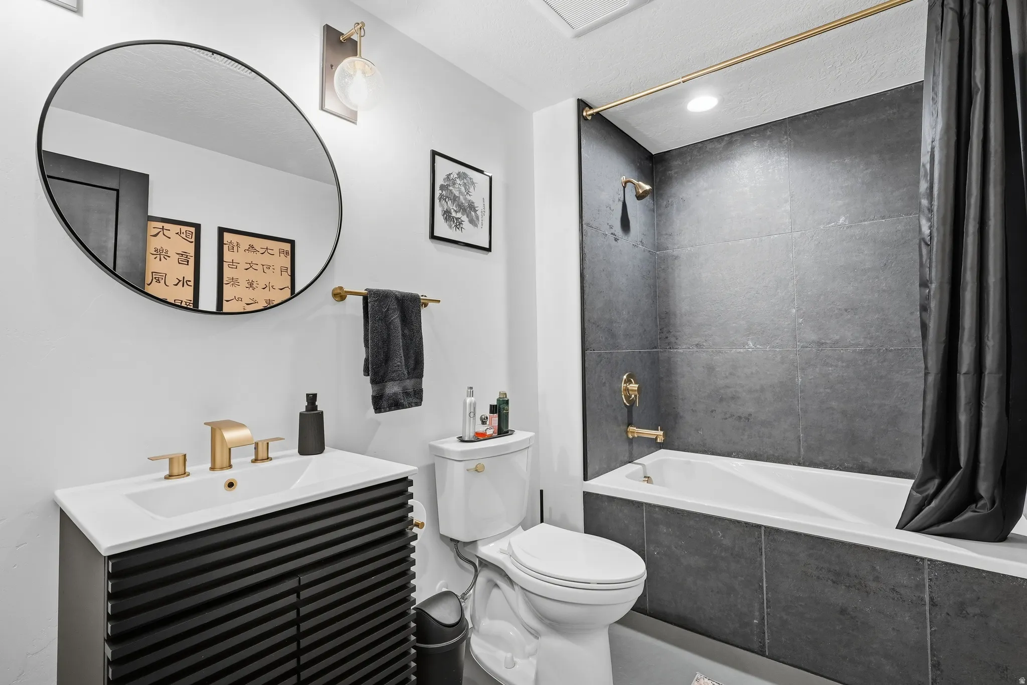 Modern bathroom featuring a vanity with a white countertop and a black textured cabinet