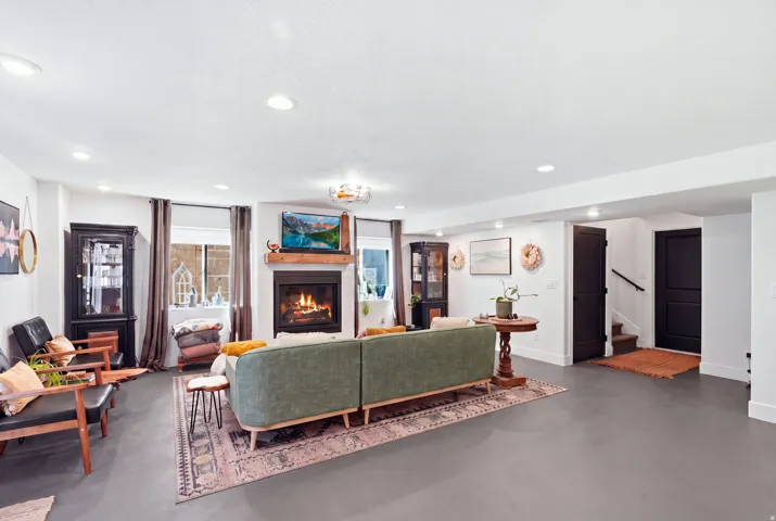 Recessed lighting, wood-finish flooring, and a fireplace with a wood mantle