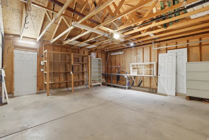 Concrete flooring and exposed wooden beam ceiling with visible rafters
