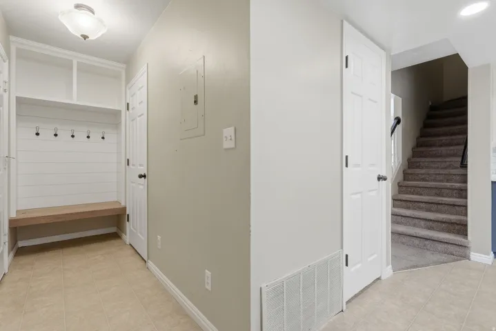 Built-in storage bench with shiplap backing, integrated coat hooks, and upper shelving