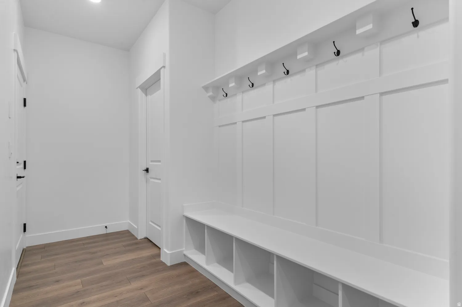Entryway featuring wood-finish flooring, recessed lighting, and a built-in bench with storage cubbies