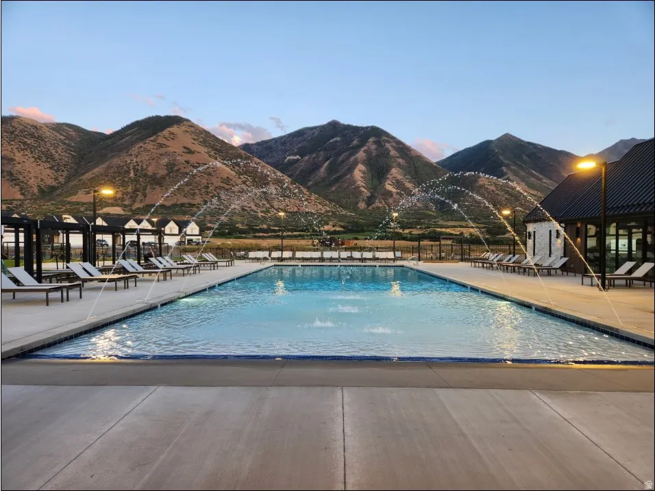 Rectangular swimming pool with integrated water features, surrounded by a concrete deck