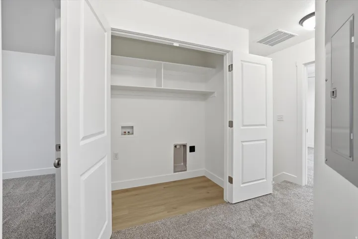 White interior doors, built-in shelving, wood-finish flooring, and light gray carpet