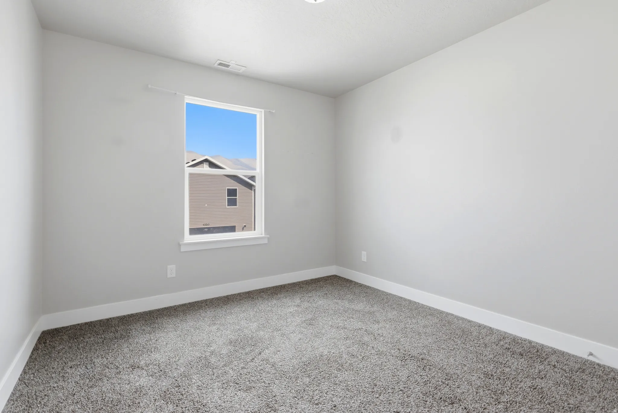Carpeted flooring, single window, white trim, recessed lighting, neutral wall palette