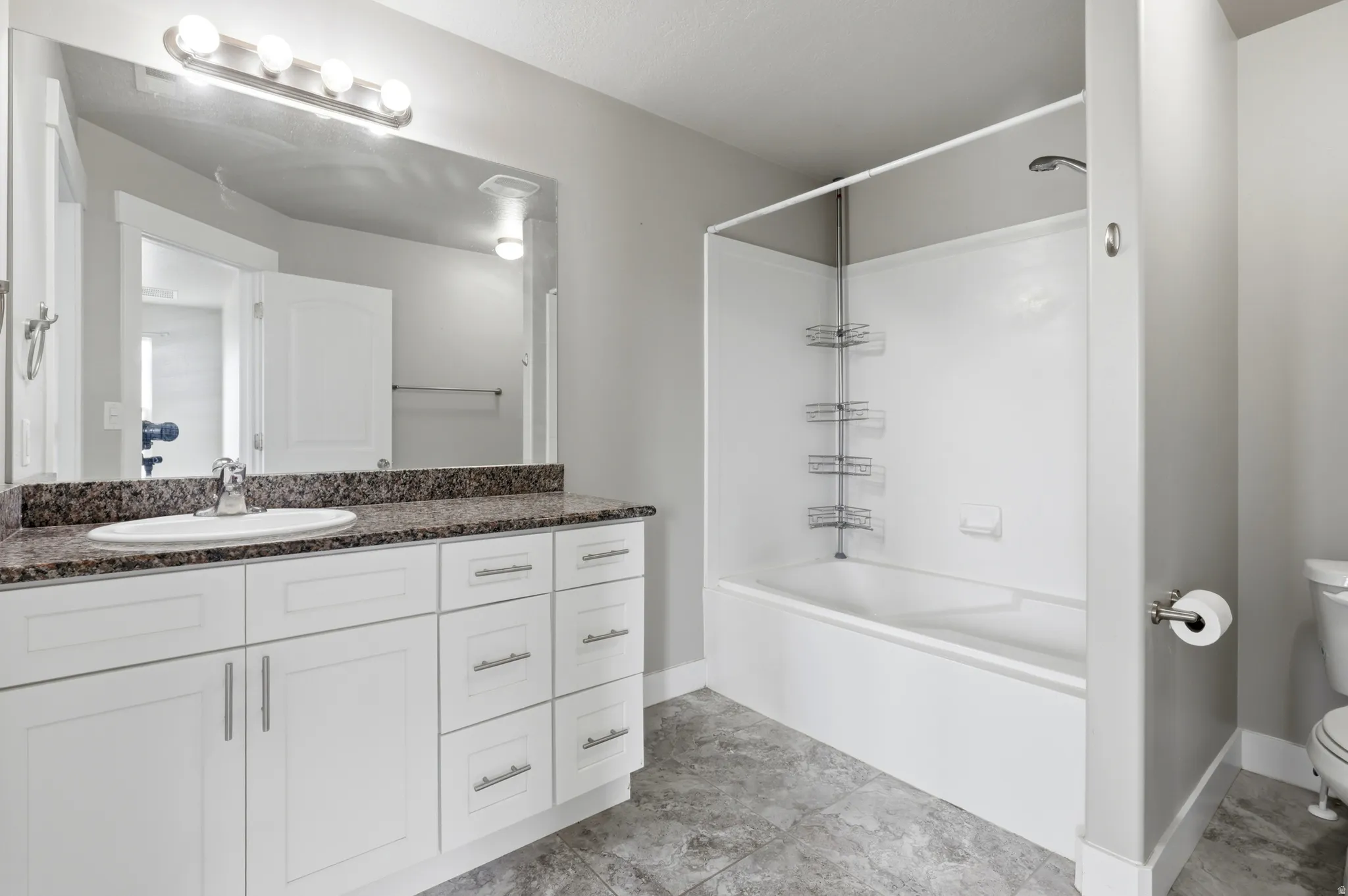 White vanity with integrated sink, speckled countertop, and chrome faucet