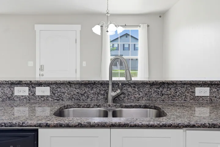 Granite countertops with an undermount stainless steel sink and a gooseneck faucet