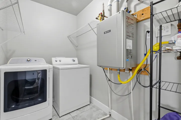 Tankless water heater installation, wall-mounted wire shelving, and tiled flooring