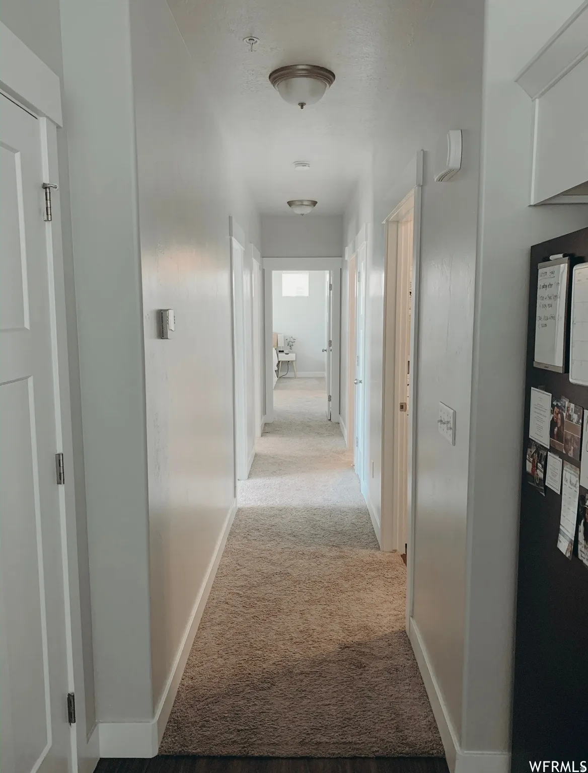 Hallway featuring recessed and flush-mount ceiling lights, light-toned carpeting, and white trim