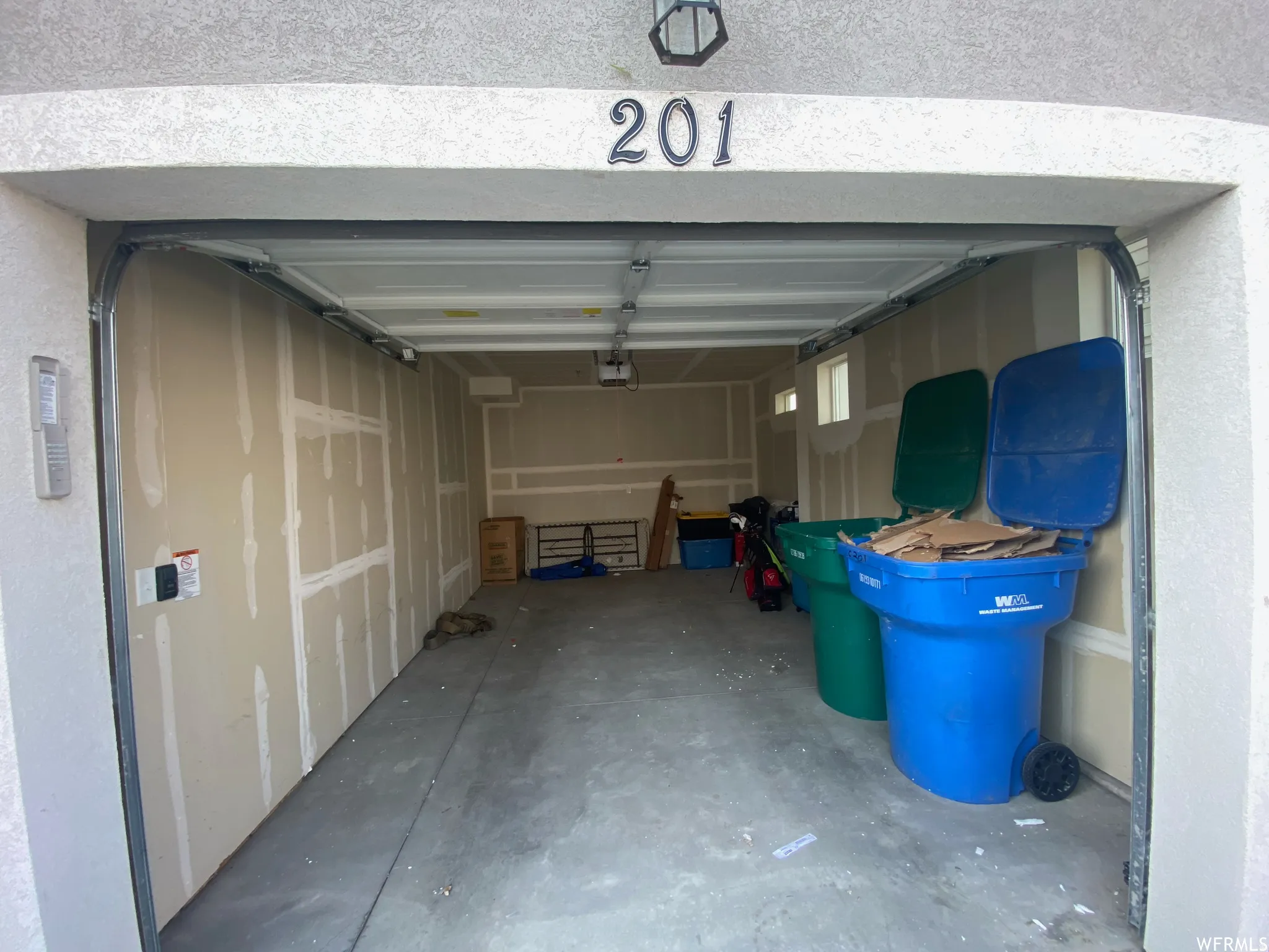 Attached garage featuring a concrete floor and unfinished walls