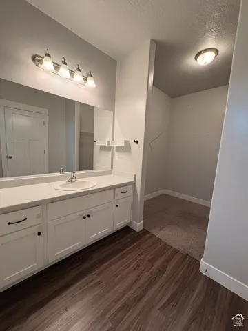 White vanity with an integrated sink, polished chrome faucet, and expansive mirror