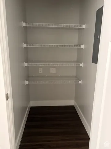 Built-in wire shelving, dark wood-finish flooring, white wall paint, and white trim