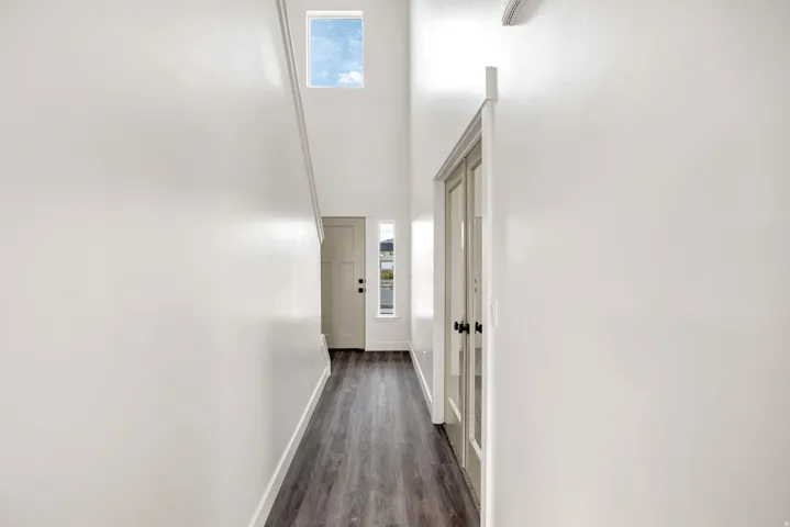 Hallway featuring wood-finish flooring, a transom window, and French doors