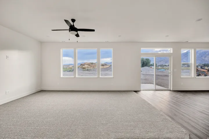 Recessed lighting, light gray carpet flooring, wood-finish flooring, ceiling fan with light, and sliding glass door