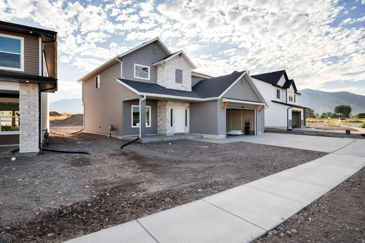 Two-story exterior with light gray siding and stone accents