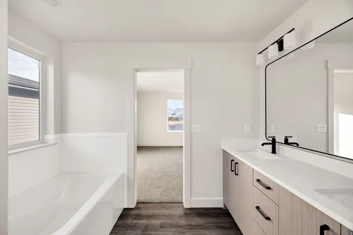 Dual vanity with undermount sinks, stone countertops, and matte black fixtures