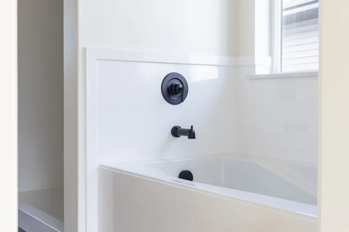 White soaking tub with matte black fixtures