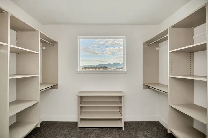 Built-in shelving, hanging rods, and a center storage unit provide ample organization