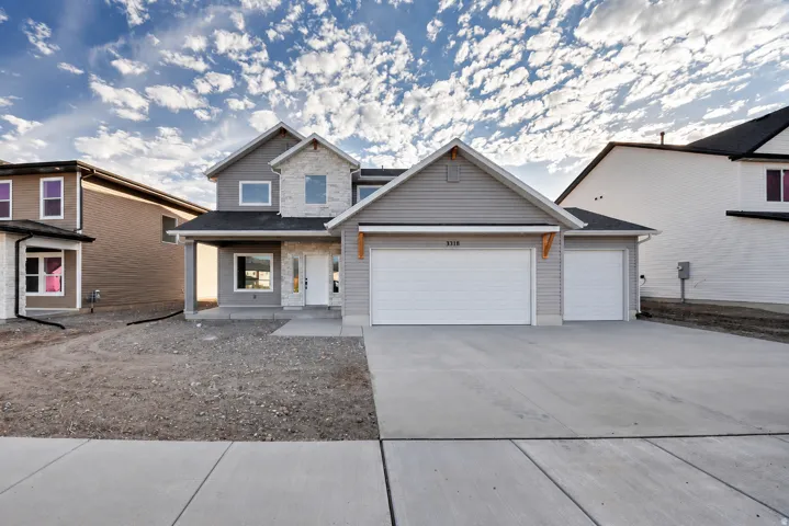 Contemporary exterior with gray siding, stone accents, and a covered front porch