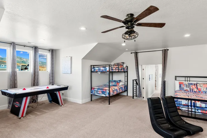 Carpeted room featuring multiple windows, recessed lighting, and a ceiling fan