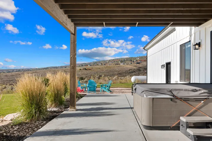 Covered patio with a concrete surface, built-in spa, and modern exterior lighting fixtures