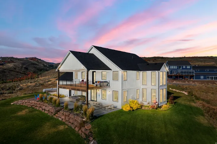 Modern farmhouse exterior with white vertical siding and black roof
