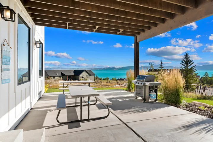 Covered patio with concrete flooring, accented by board and batten siding, and exterior lighting fixtures