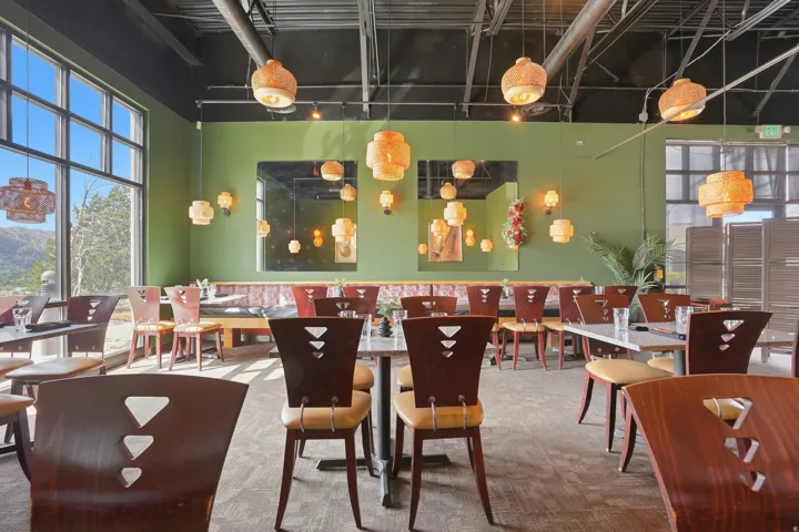 Expansive windows, high ceilings with exposed ductwork, wall-mounted light fixtures, textured carpet, and green wall finishes
