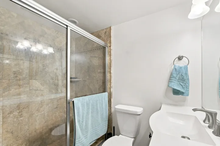 Shower with glass enclosure and full-height tile surround