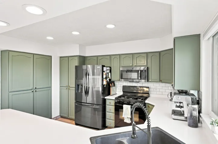 Recessed lighting, extensive cabinetry, stainless steel appliances, subway tile backsplash, and a large sink
