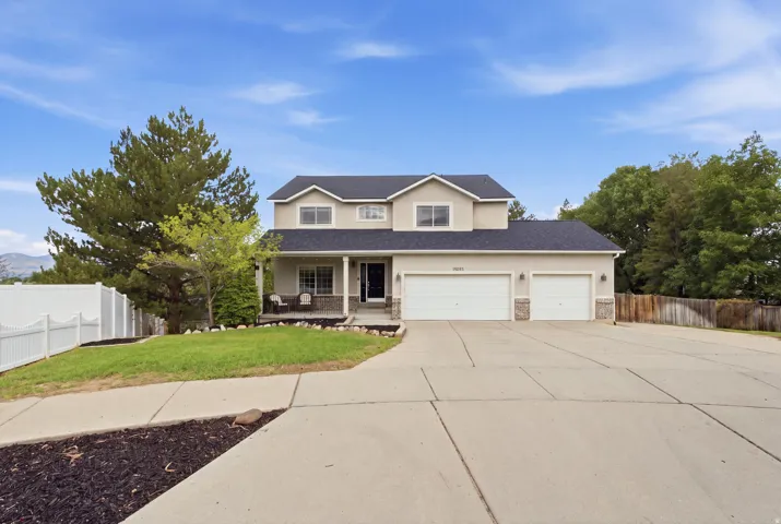 Two-story residence featuring a stucco exterior, stone accents, and a covered front porch