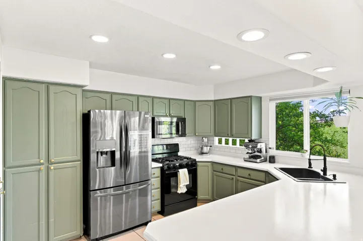 Kitchen featuring sage green cabinetry, stainless steel appliances, white subway tile backsplash, white countertops, and recessed lighting