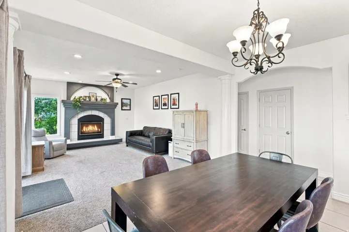 Living area featuring a fireplace with a decorative mantel, recessed lighting, and a ceiling fan