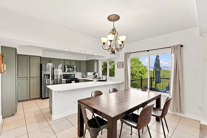 Expansive kitchen with ample cabinetry, a white tile backsplash, and stainless steel appliances