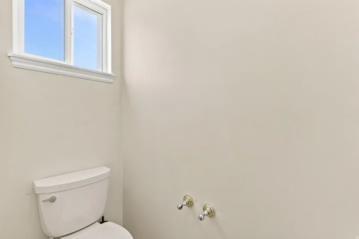 White framed window with trim detail, bright interior wall finish, and polished chrome plumbing fixtures