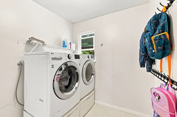 Dedicated laundry area with a large window and overhead wire shelving