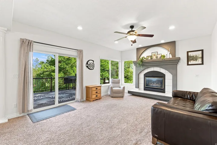 Living area featuring a fireplace with a mantel, a ceiling fan with integrated lighting, and recessed ceiling lighting