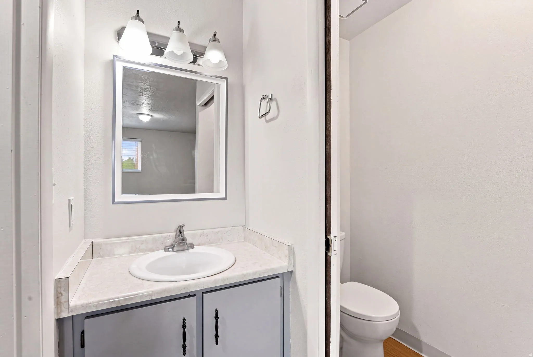 Vanity with integrated sink, chrome faucet, and cabinet storage