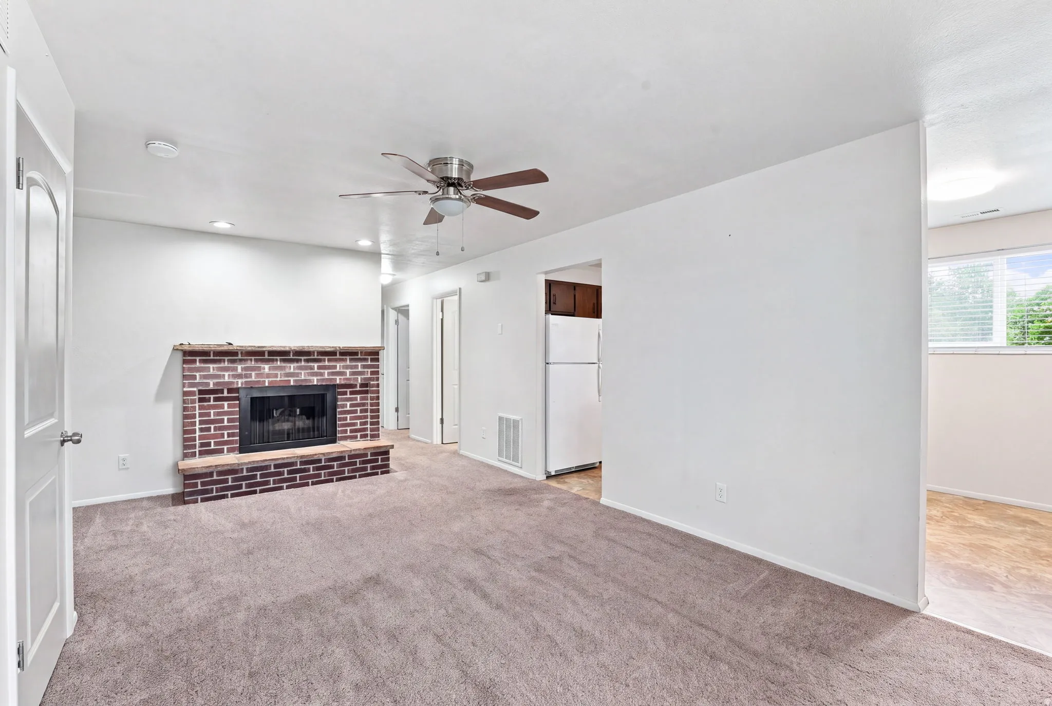 Brick fireplace with hearth, recessed lighting, and ceiling fan