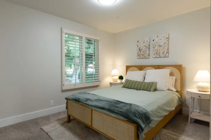 Wall-to-wall carpeting with a light ceiling fixture and window featuring plantation shutters